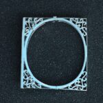 Pulsera rígida cuadrada en oro blanco 18K con diseño calado en filigrana curvilínea y acabado espejo