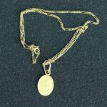 Collar religioso de oro amarillo 18K con dije ovalado grabado de Ganesh